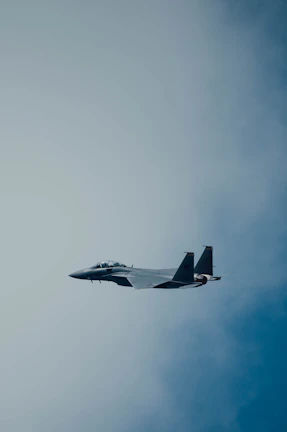 Close-up of a sleek fighter jet soaring against a clear blue sky.