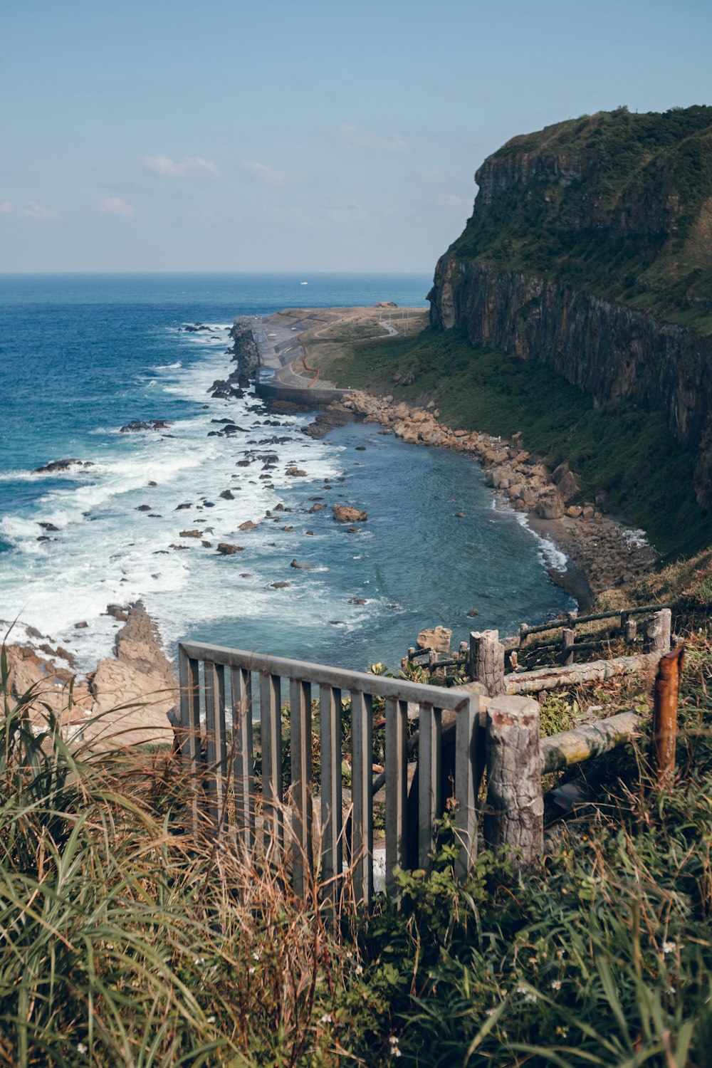 brown wooden fence on brown rock formation near body of water during daytime