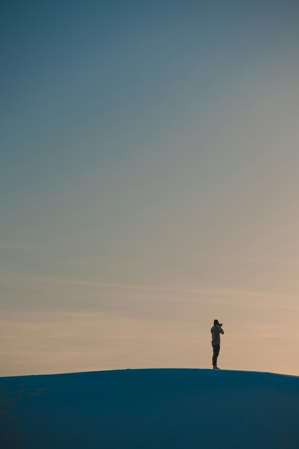 silhouette of man standing on hill during daytime