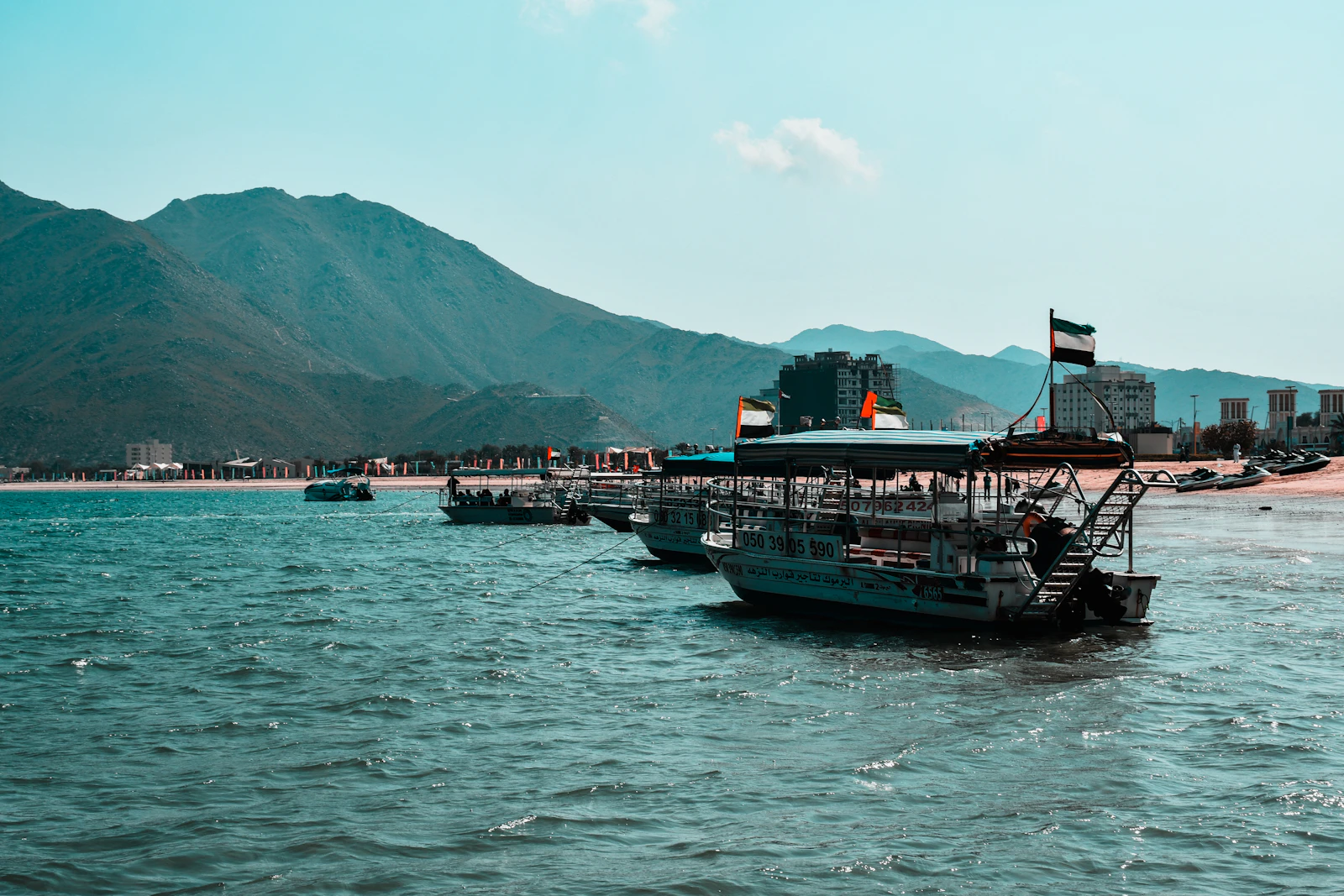 Boats in the bay at Khorfakkan, backed by the Hajar Mountains