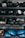 Several shelves filled with various gym equipment, including black medicine balls, blue half-balance balls, and other exercise tools. The equipment is neatly organized, with larger items placed on the lower shelves and smaller weights at the top.