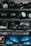 Several shelves filled with various gym equipment, including black medicine balls, blue half-balance balls, and other exercise tools. The equipment is neatly organized, with larger items placed on the lower shelves and smaller weights at the top.