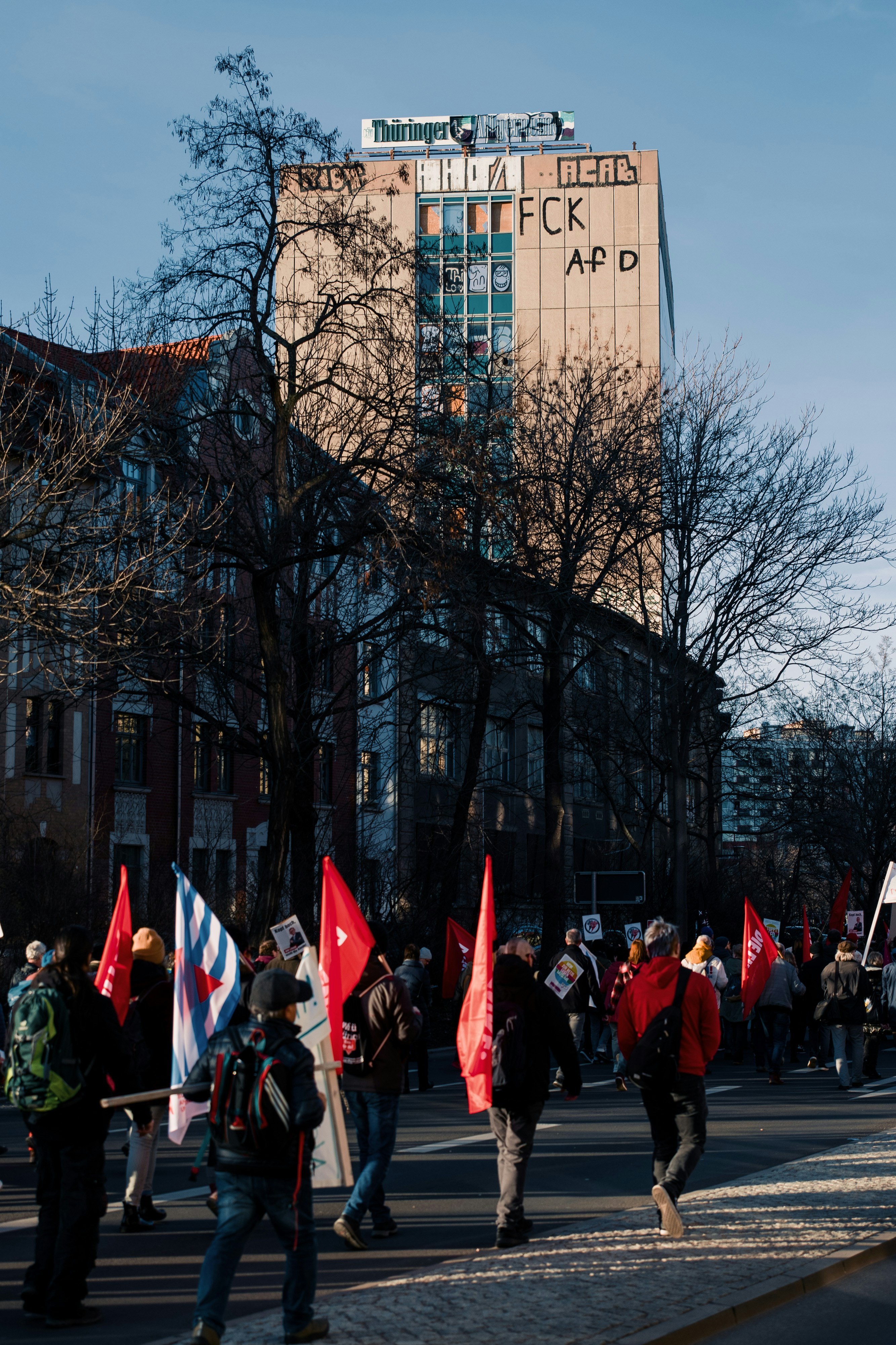 people in red and black suits standing near building during daytime