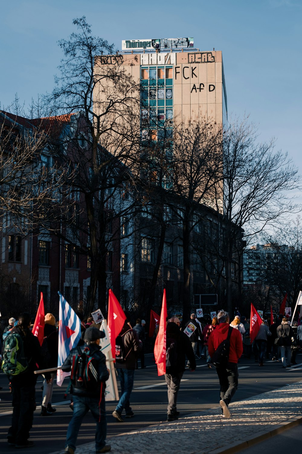 people in red and black suits standing near building during daytime