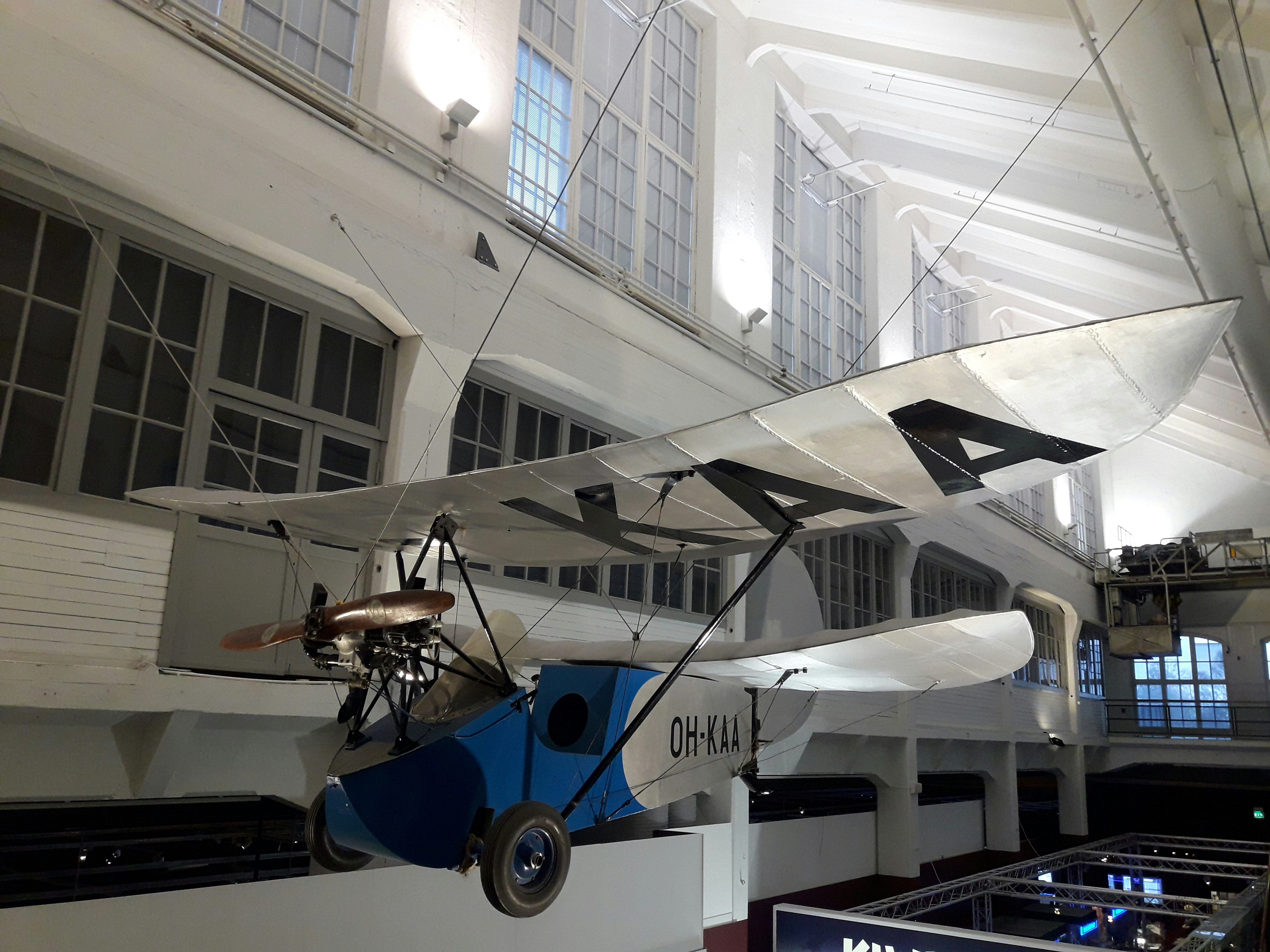 blue and white airplane in the middle of white building, Mignet HM-14 Pou du Ciel at Vapriikki Museum , Tampere, Finland