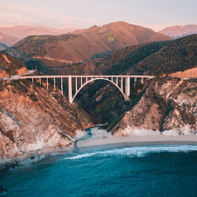 gray concrete bridge over blue sea during daytime