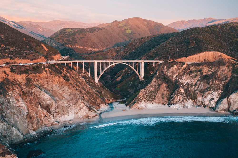 gray concrete bridge over blue sea during daytime