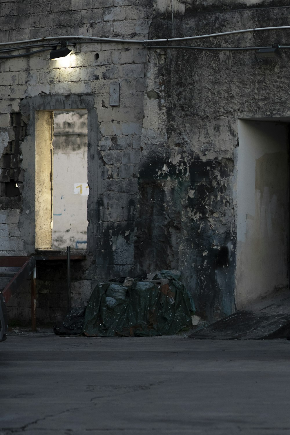 gray concrete building with green plastic bags