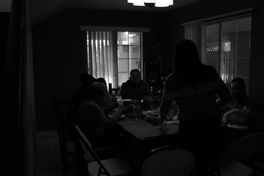 Guests dining with blindfolds, savoring mysterious dishes in a cozy, dimly lit setting.