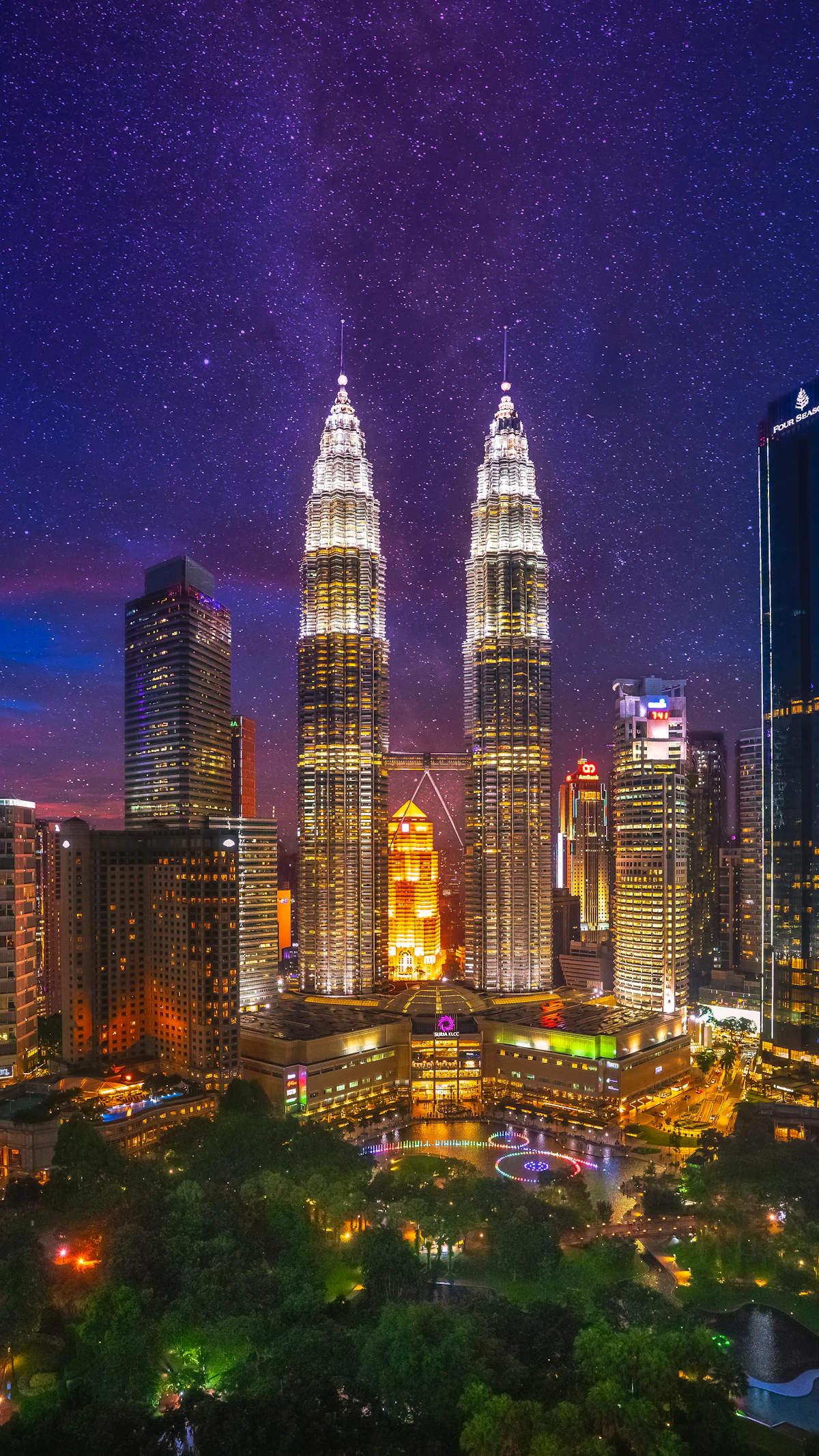 Kuala Lumpur city buildings lit up at night, real estate Malaysia