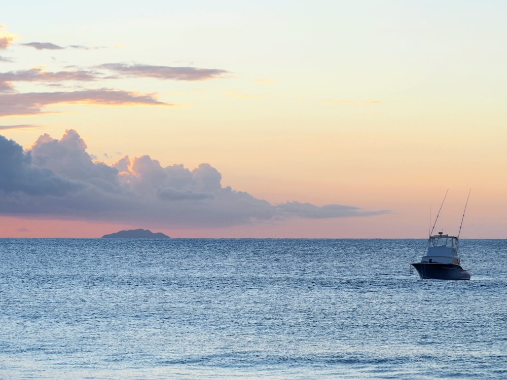 silhouette of boat on sea during sunset