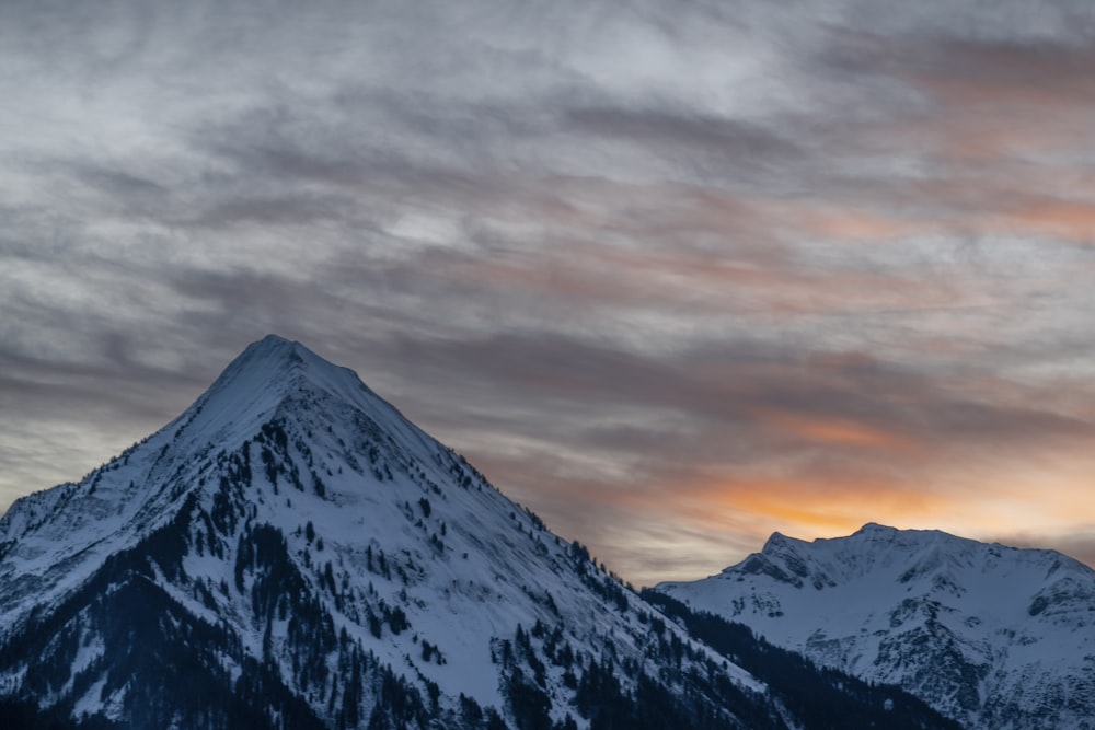 snow covered mountain under cloudy sky during daytime