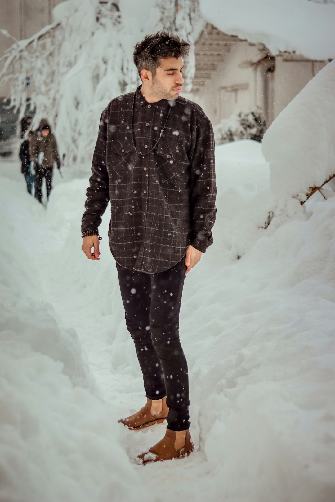 man in black and gray striped coat standing on snow covered ground during daytime