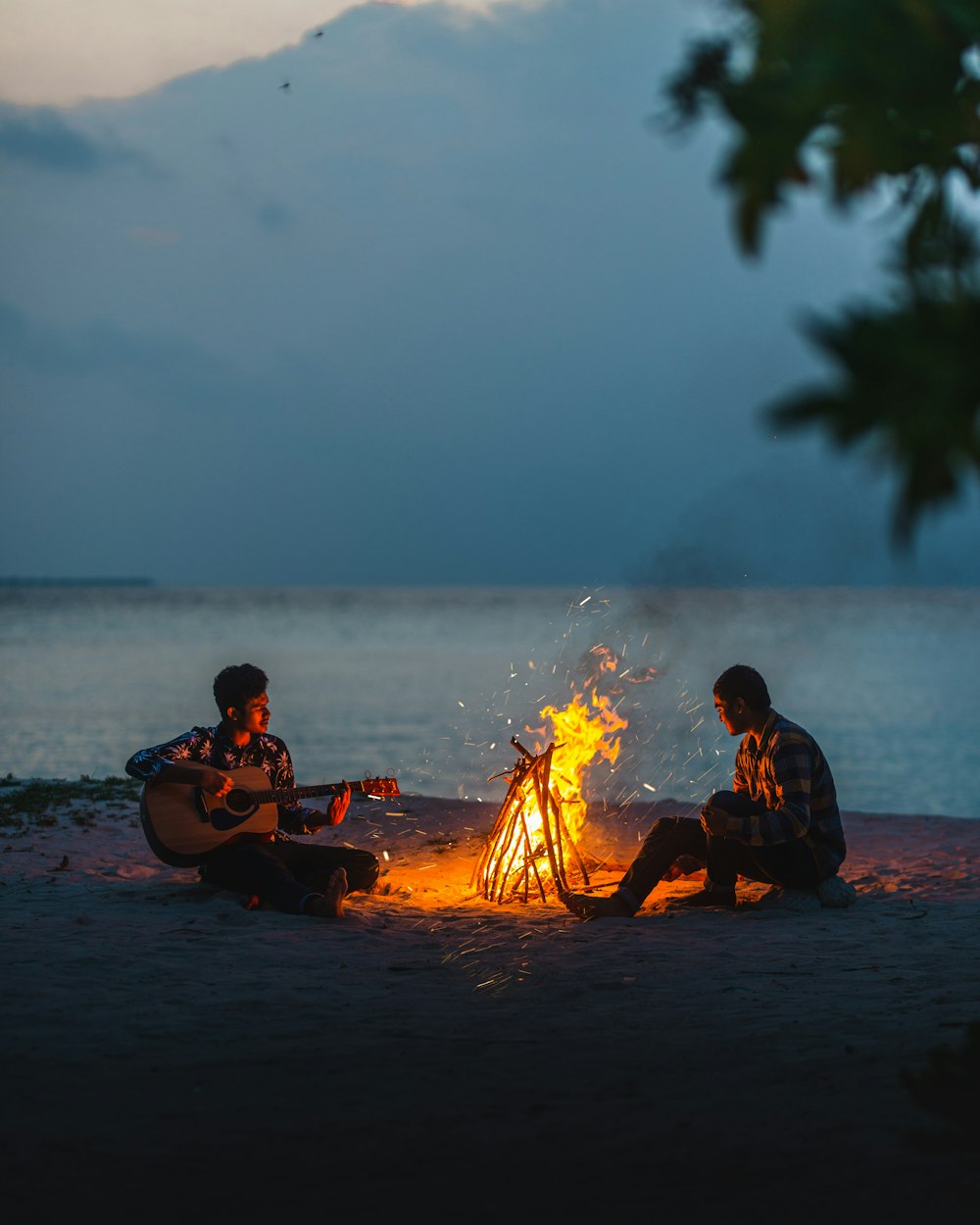 people sitting on beach shore during sunset