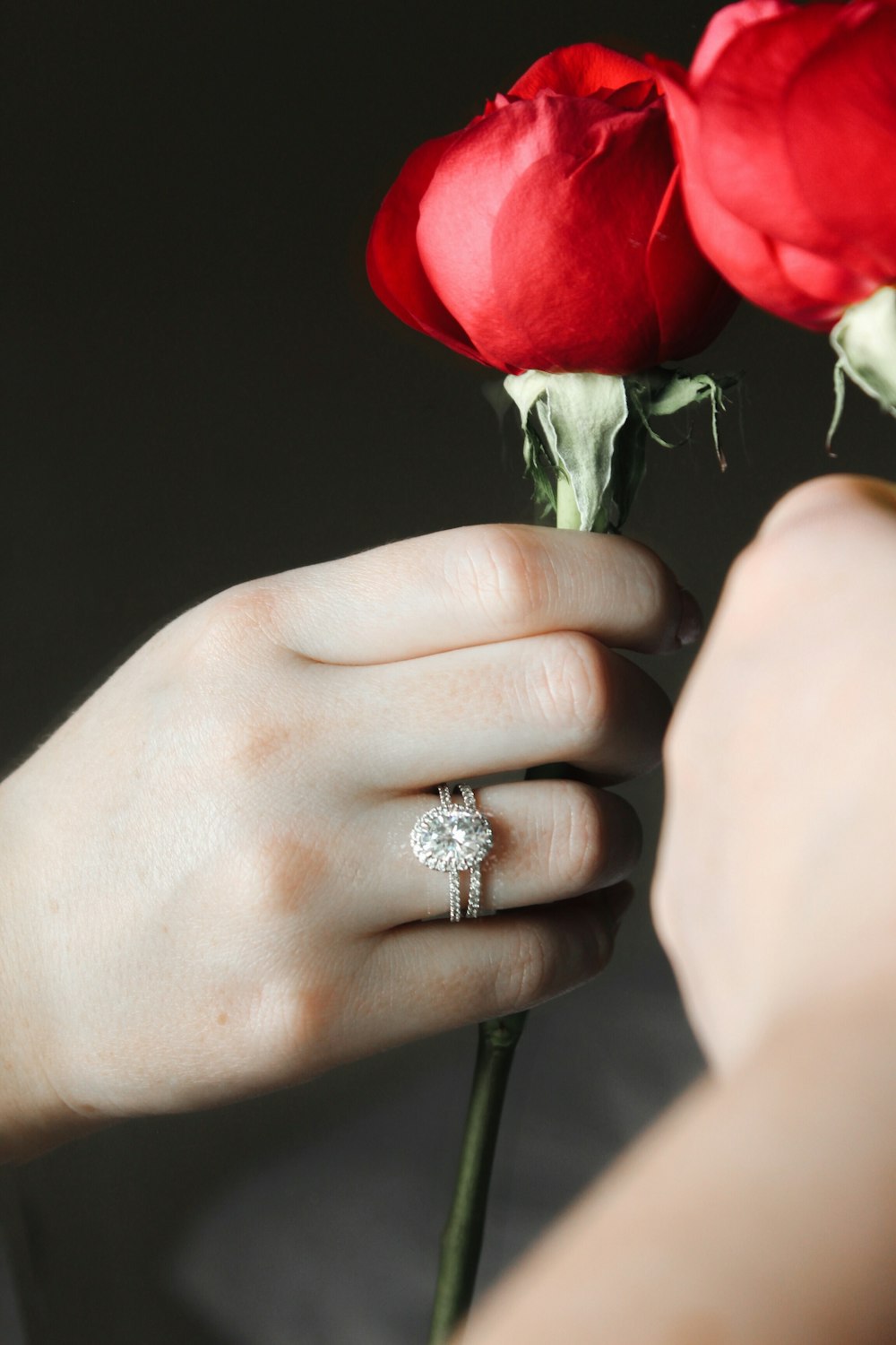 silver diamond ring on persons hand