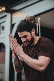 man in black crew neck t-shirt with tattoo on his left hand
