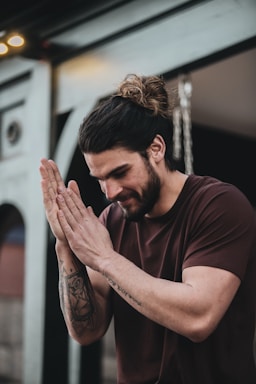 man in black crew neck t-shirt with tattoo on his left hand
