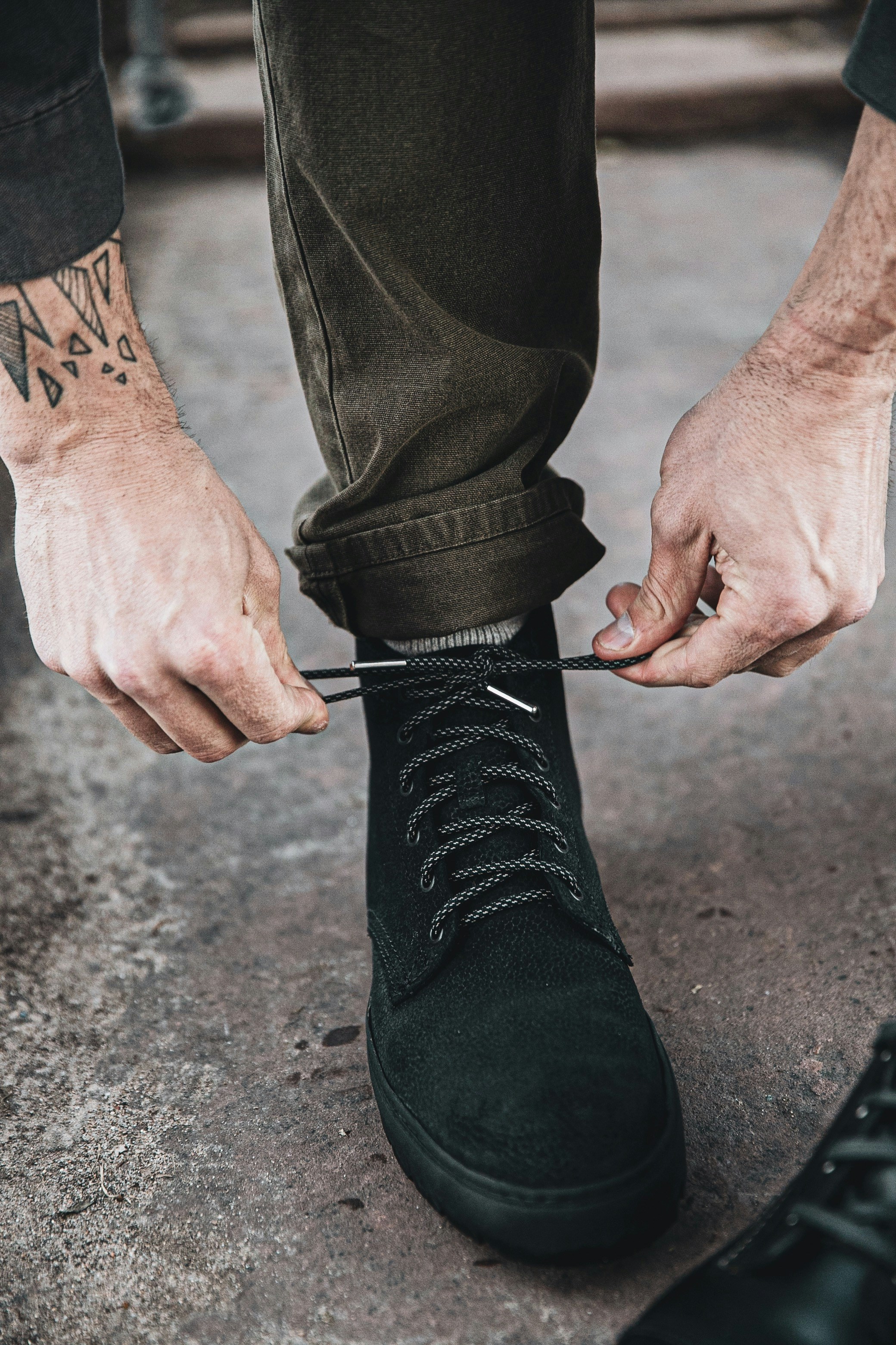 A child practicing tying their shoelaces on a practice board.