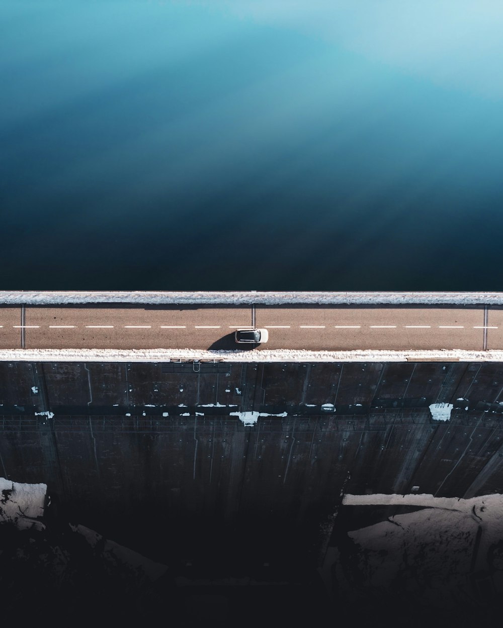 gray concrete wall beside body of water during daytime