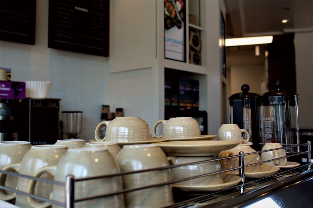 white ceramic mugs on stainless steel rack