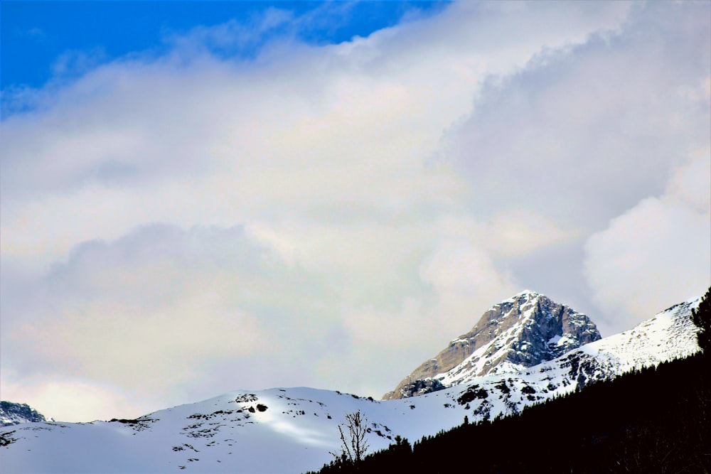 snow covered mountain under cloudy sky during daytime