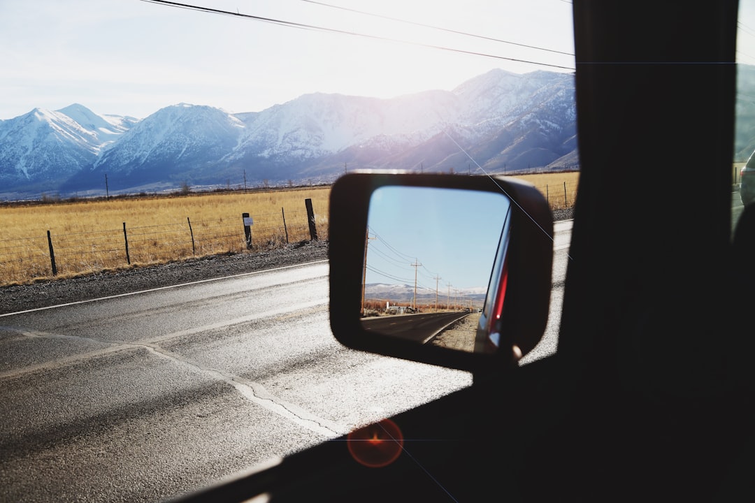 car side mirror with view of mountains during daytime