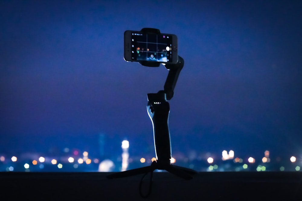 black smartphone taking photo of city lights during night time