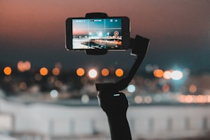 person taking photo of city during sunset
