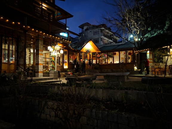 An inviting outdoor patio of a restaurant glowing with warm evening lights.