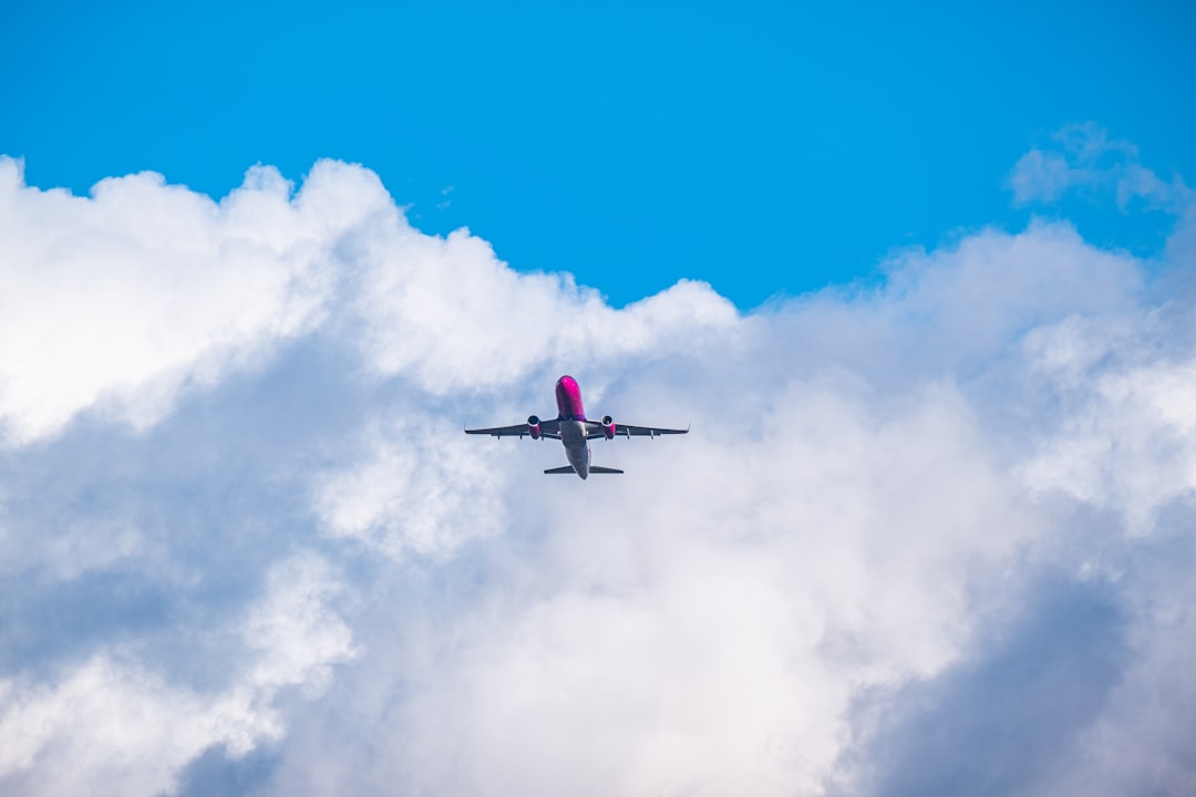 red and white airplane flying in the sky