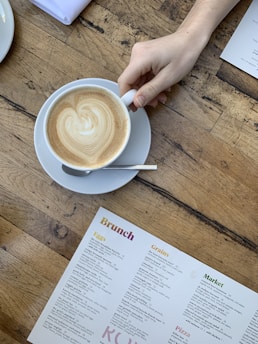 cappuccino on white ceramic cup on white ceramic saucer
