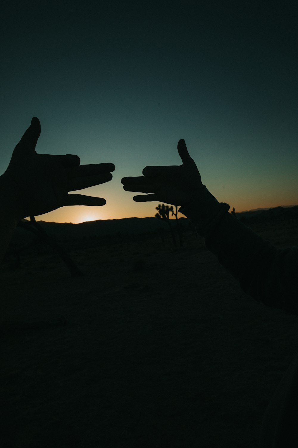 silhouette of person sitting on chair during sunset