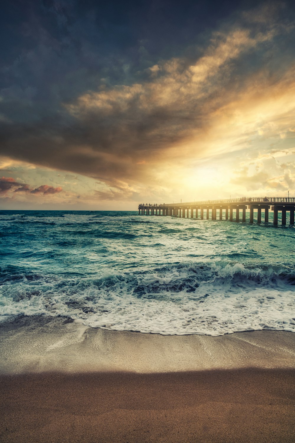 sea waves crashing on shore during sunset