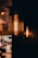 A close-up of a rustic wooden pendant light casting a soft glow over a farmhouse kitchen table.