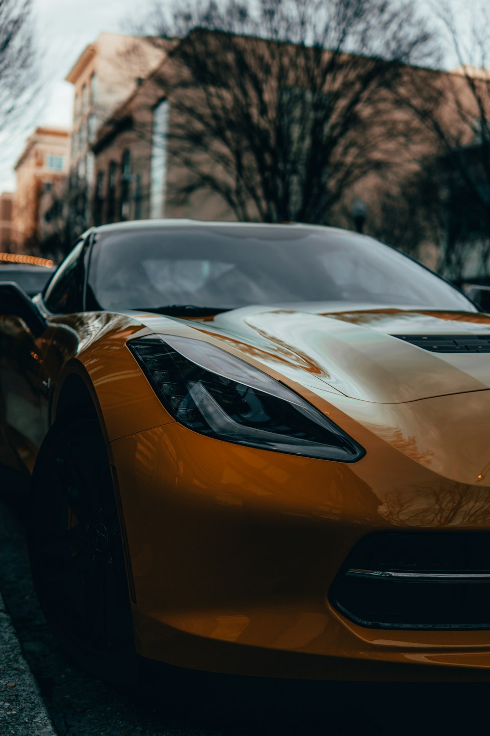 yellow car parked near brown building during daytime