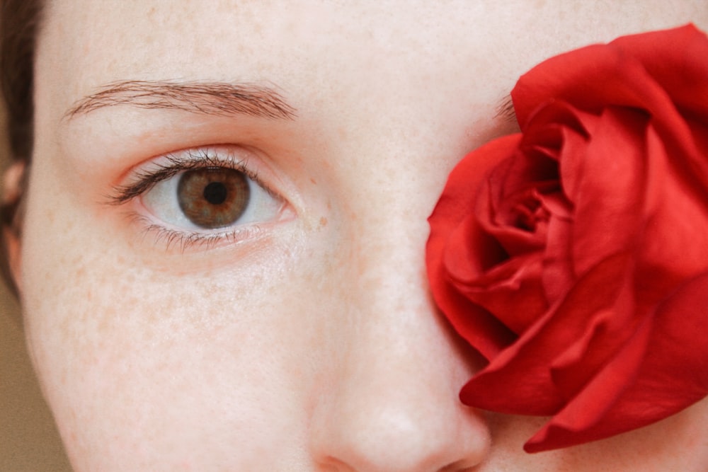 woman with red rose on her ear