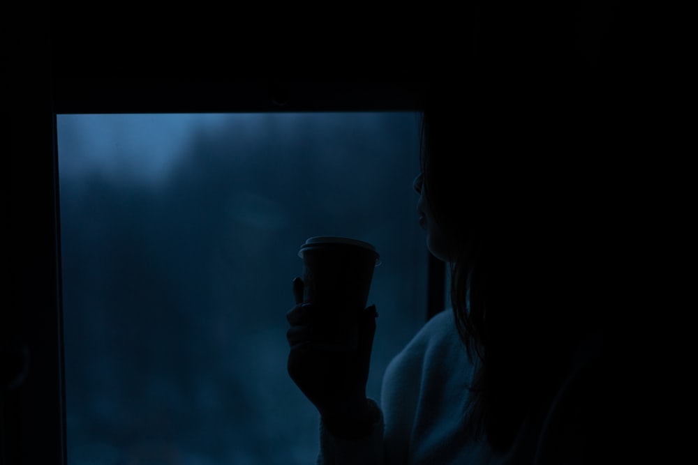 person holding black disposable cup