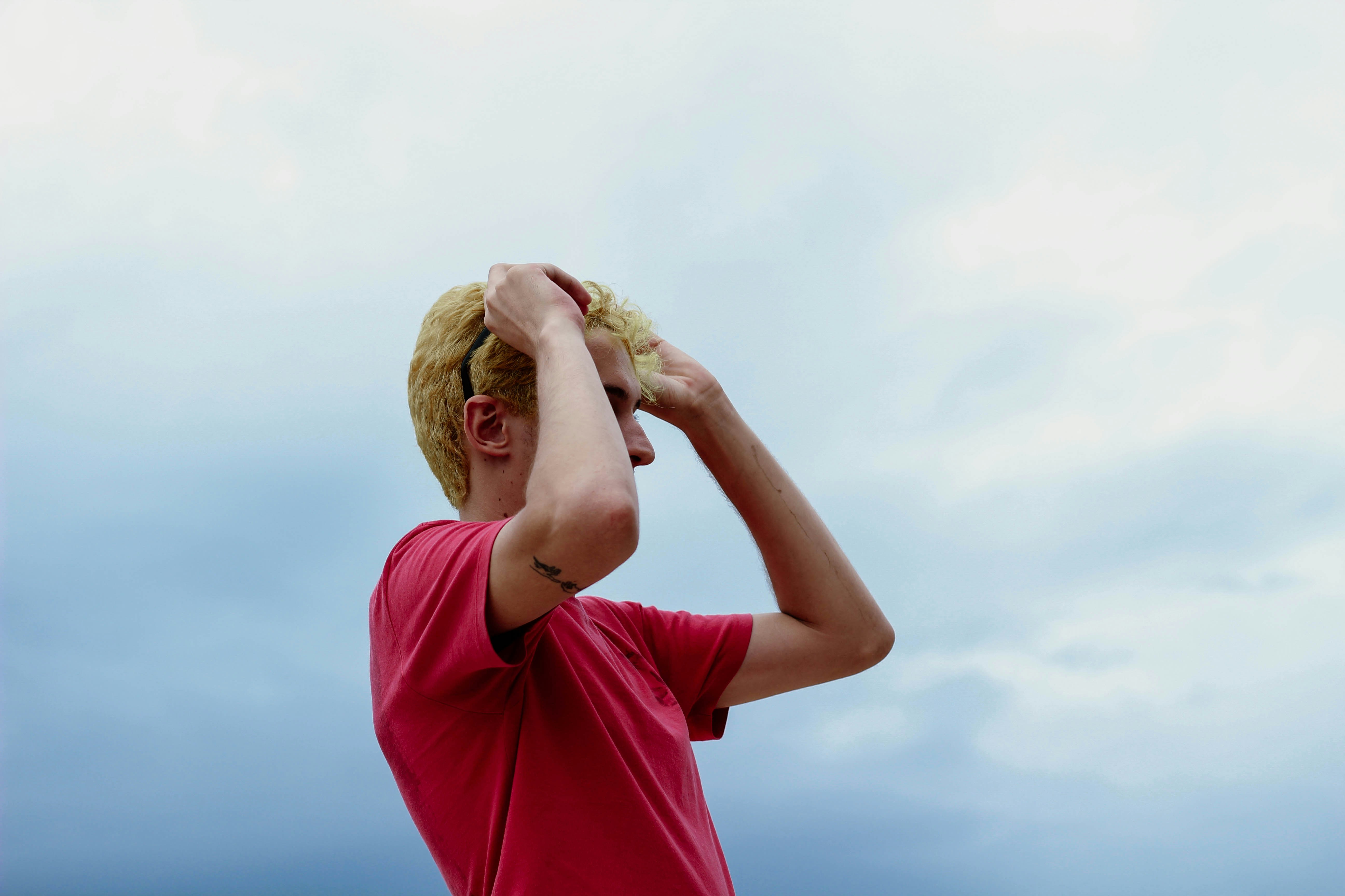 woman in pink shirt covering face with brown textile