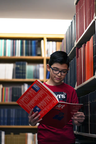 man in red crew neck shirt holding red book