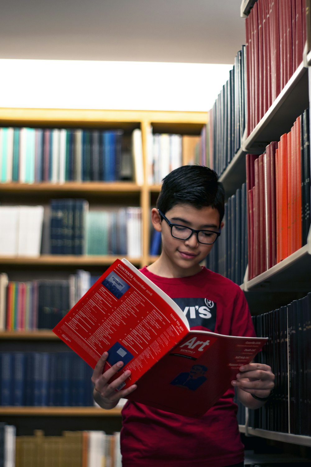 man in red crew neck shirt holding red book