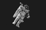 astronaut in white suit in grayscale photography