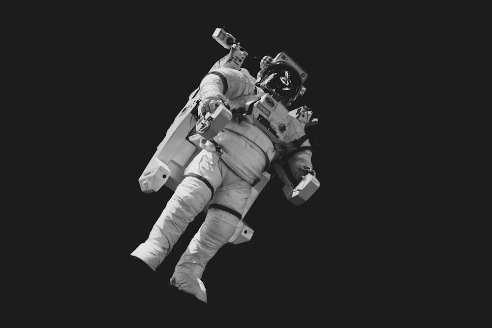 astronaut in white suit in grayscale photography