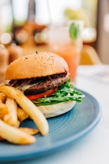 burger with lettuce and tomato on blue ceramic plate