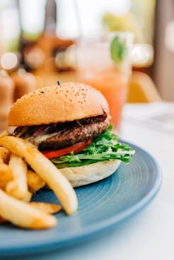 burger with lettuce and tomato on blue ceramic plate