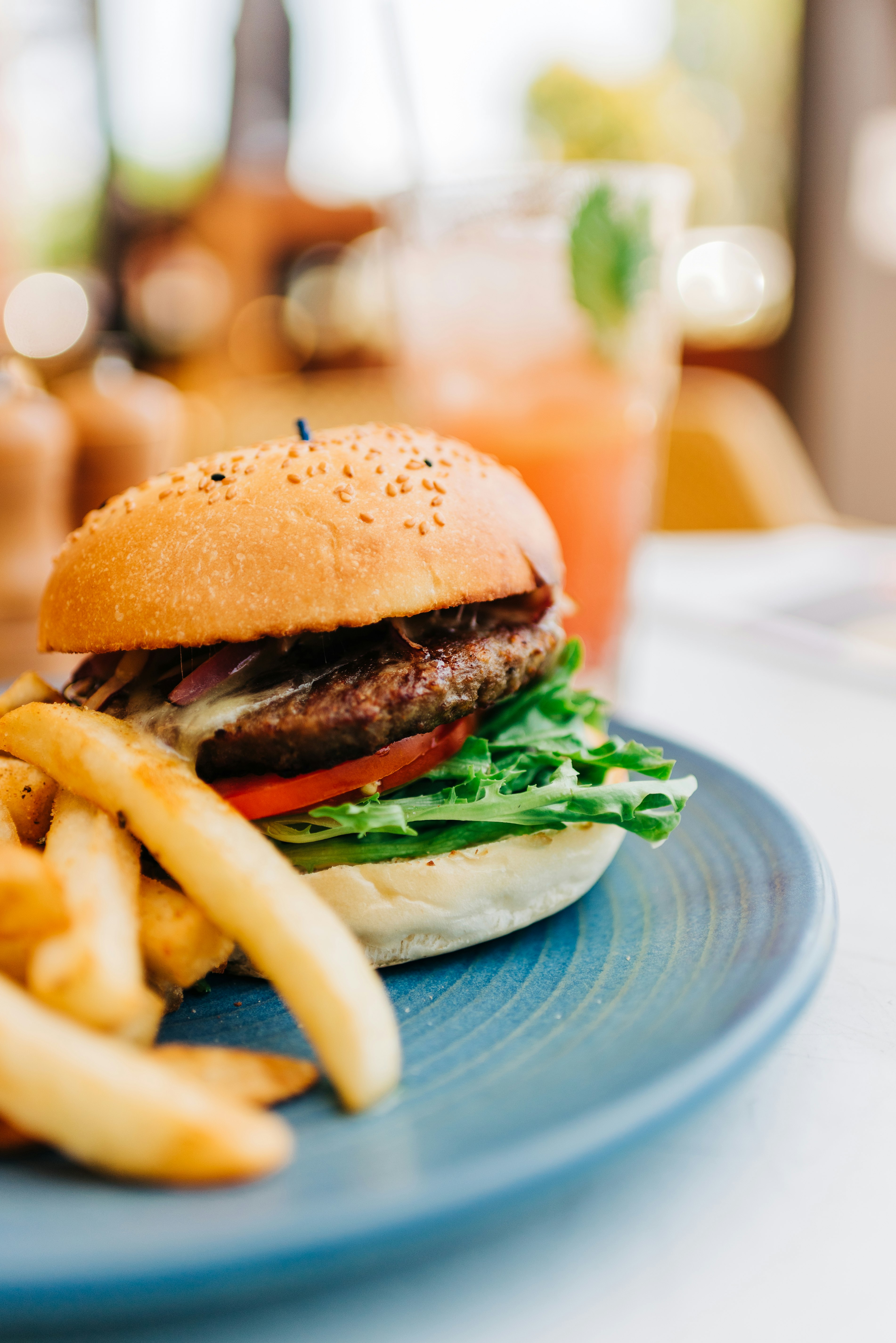 burger with lettuce and tomato on blue ceramic plate