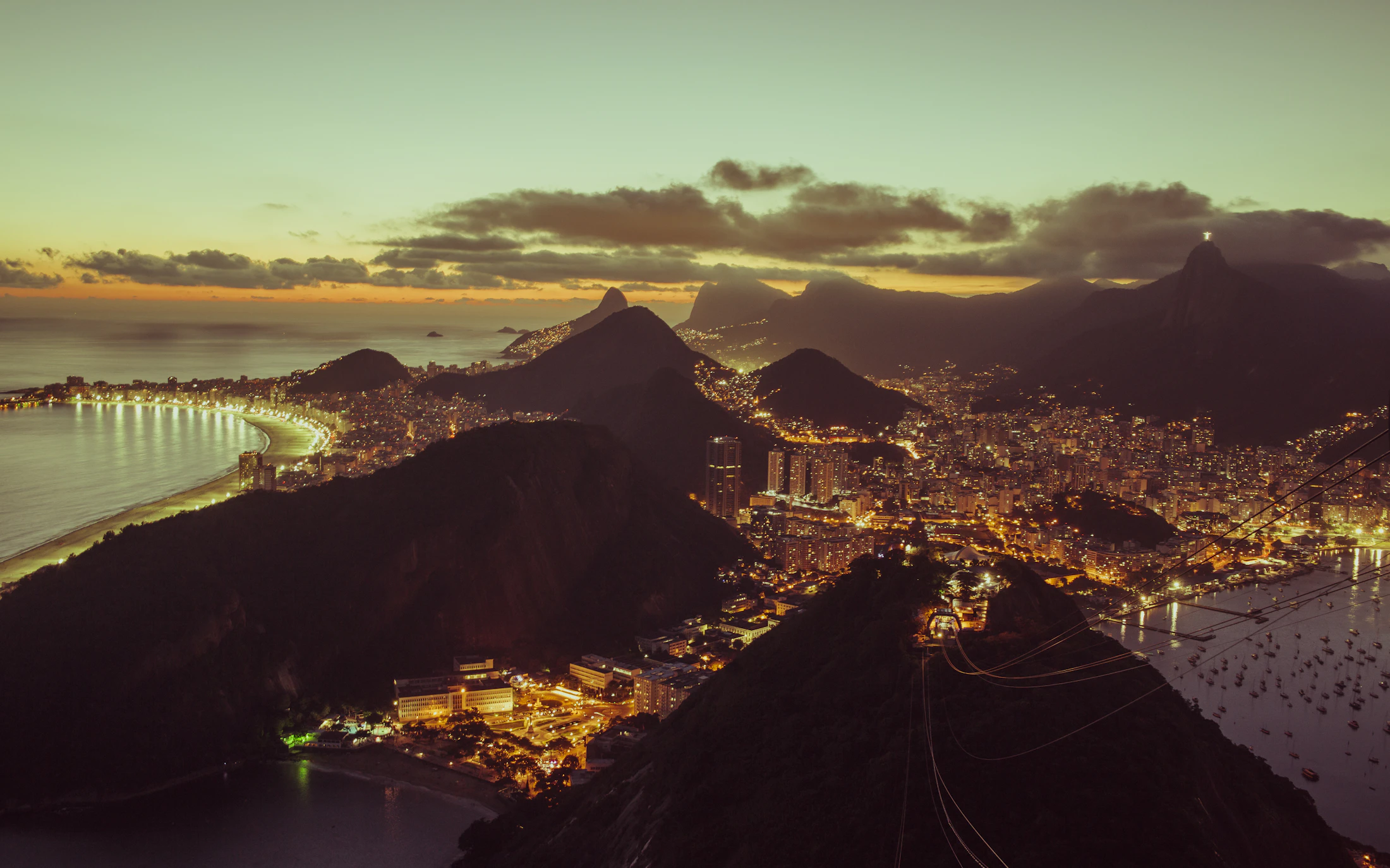 Rio de Janeiro at night from above, lit favelas and the sweep of the bay