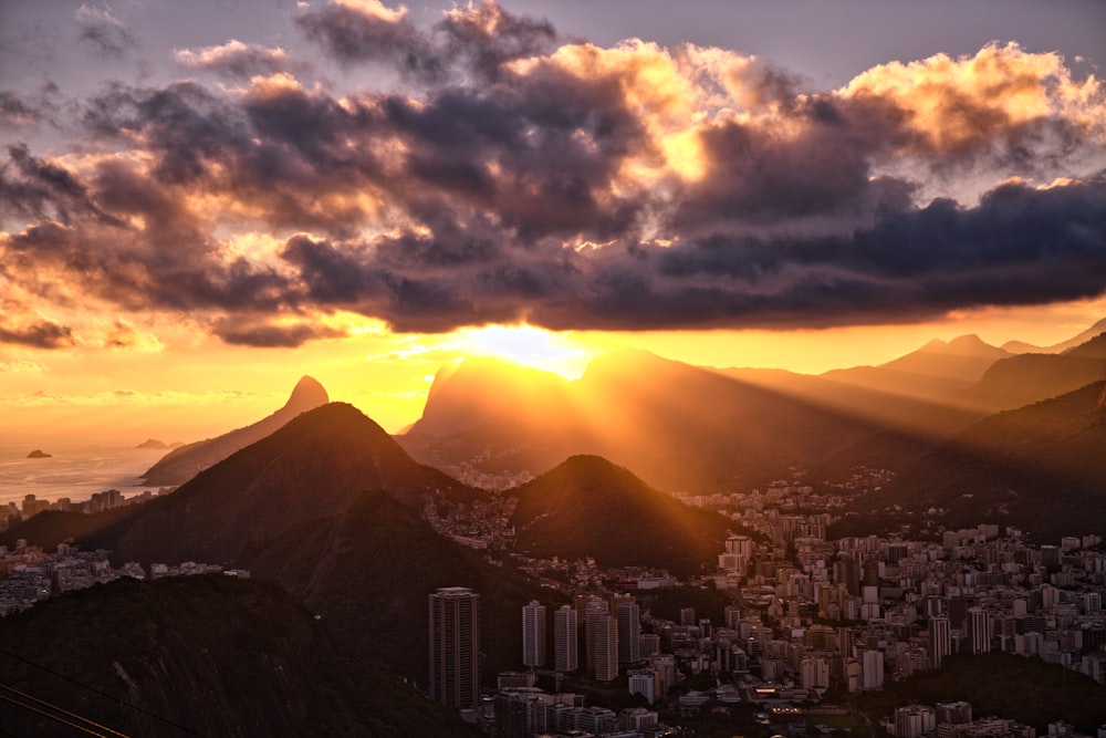 edificios de la ciudad cerca de la montaña bajo el cielo nublado durante el día