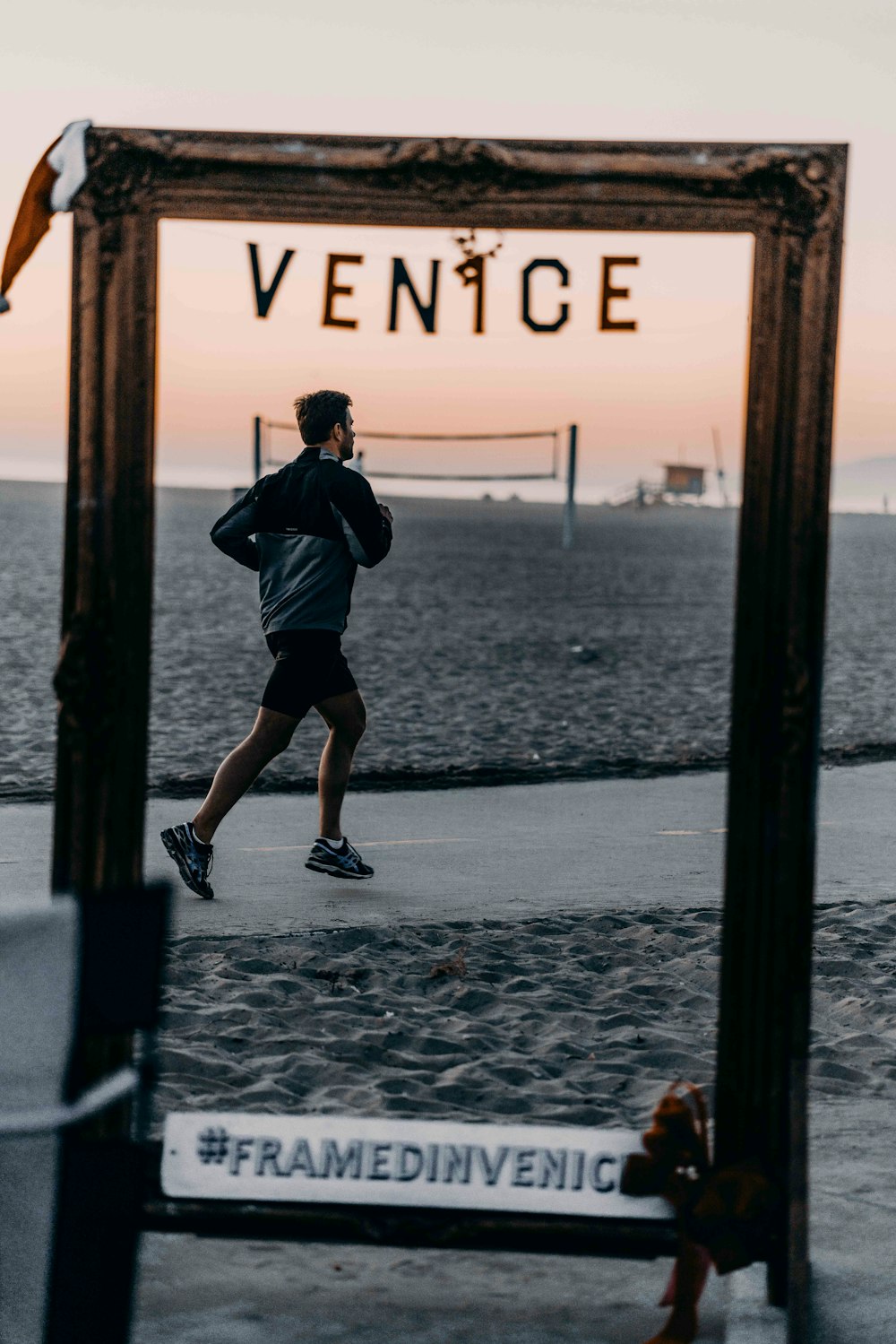 man in black t-shirt and black shorts standing on beach shore during daytime