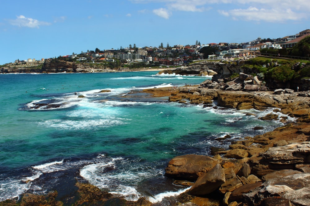 sea waves crashing on rocks during daytime