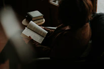 A serene scene of a person reading a psychology book in a cozy, softly lit room.